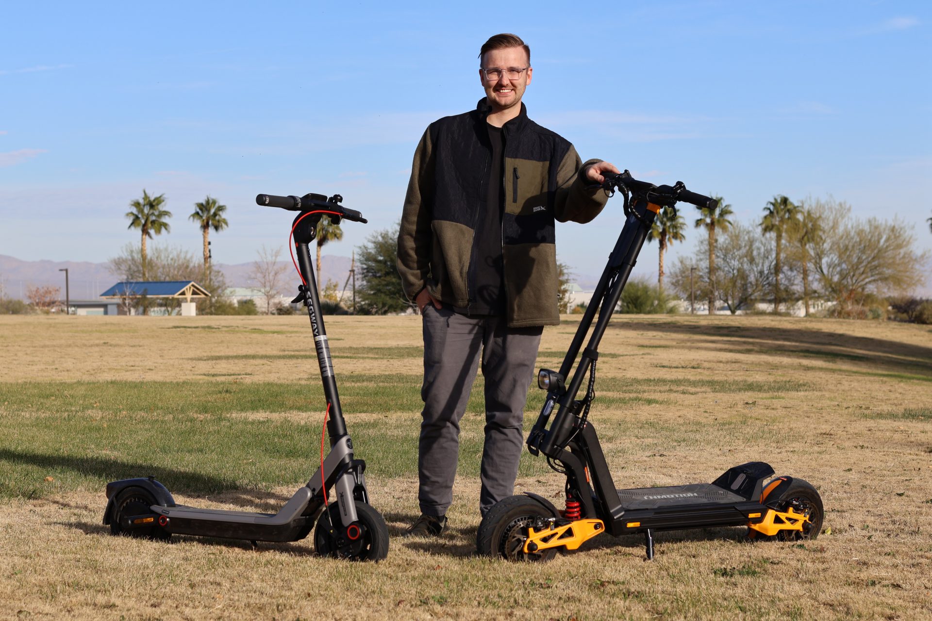 Mitchell Anderson with two scooters in park